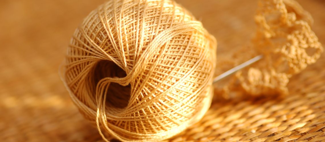 Yarn ball with needle on wicker table